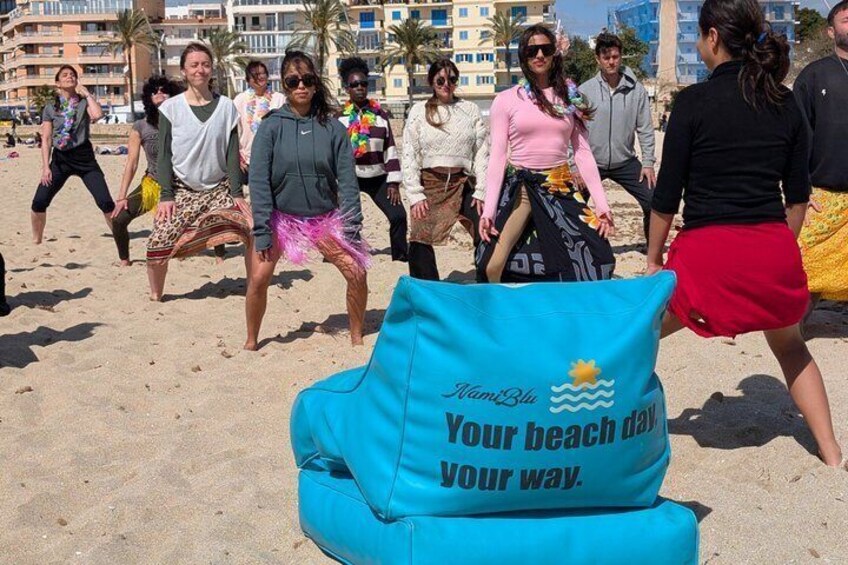 A group of people on a beach with a blue cushion that reads 'Miami Beach Your beach day Your way.' 2