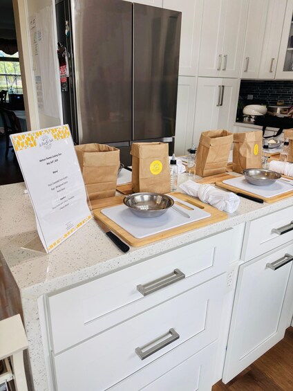 A kitchen with white cabinets, a stainless steel refrigerator, and a menu stand. 3