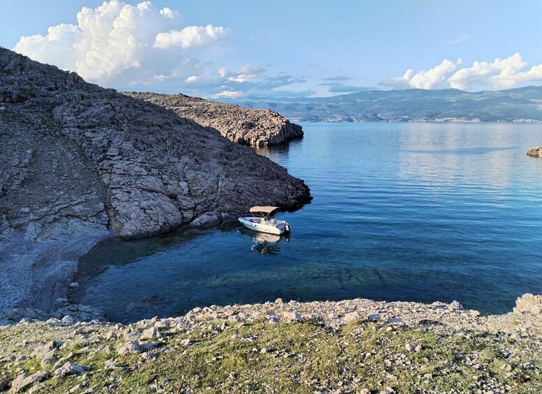 A rocky coastline with a boat anchored near the shore. 3