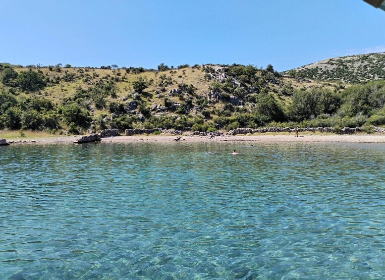 A clear lake with a rocky shoreline and sparse vegetation. 2