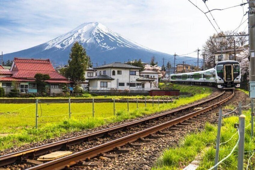 A train on tracks with a snow-capped mountain in the background. 3