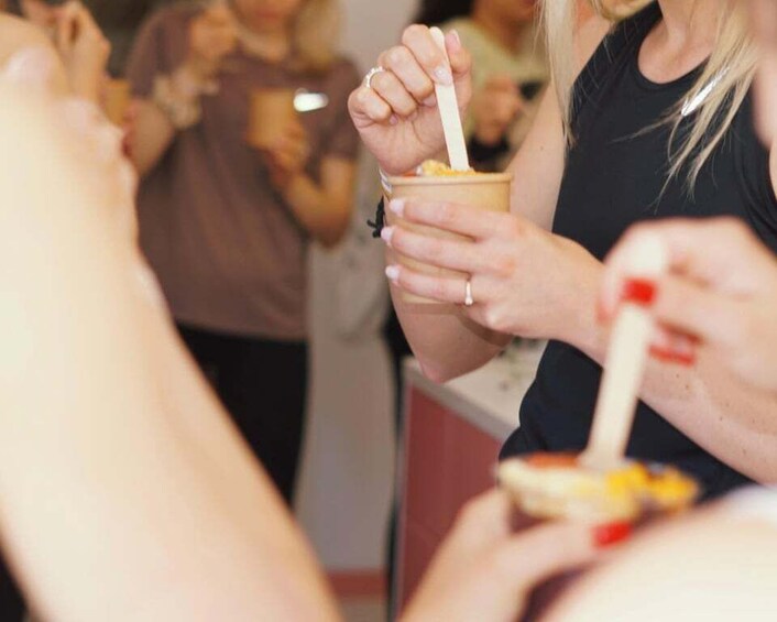 A person holding a cup with a spoon, likely eating or drinking. 1