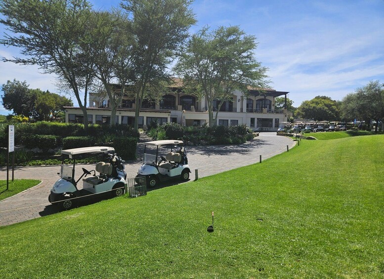 A golf course with a clubhouse, golf carts, and a well-maintained lawn. 3