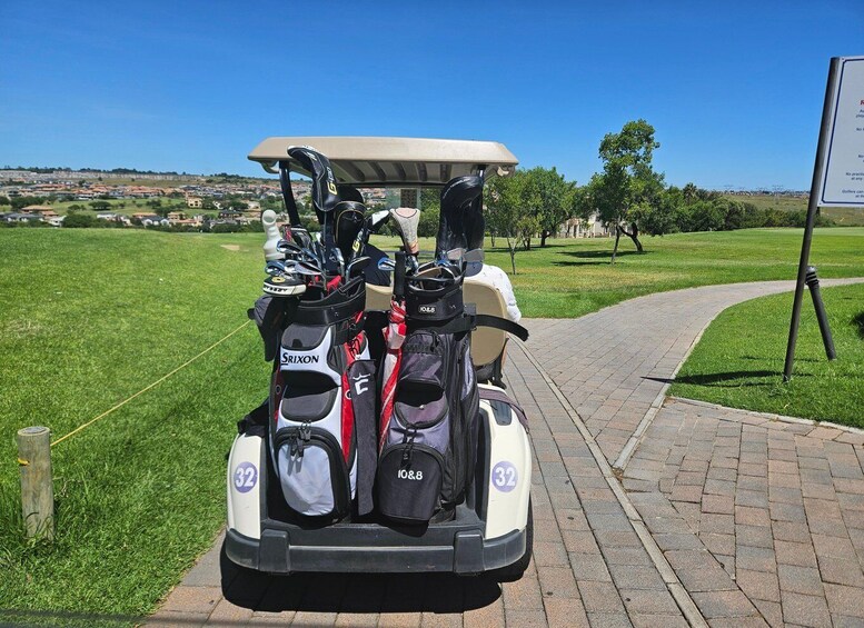 A golf cart with multiple bags and a sign in a park. 2
