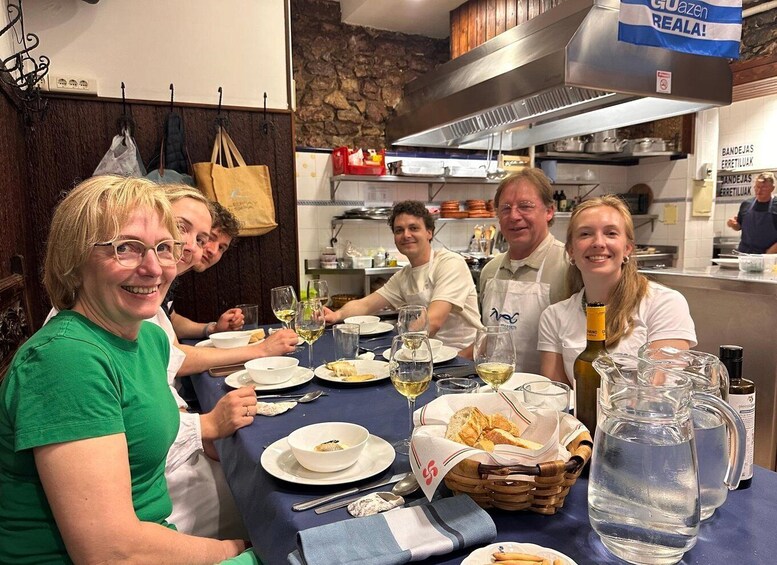 A group of people dining at a restaurant with a stone wall and kitchen in the background. 3
