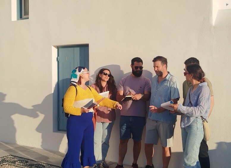 A group of people standing outside a building with a blue door. 4