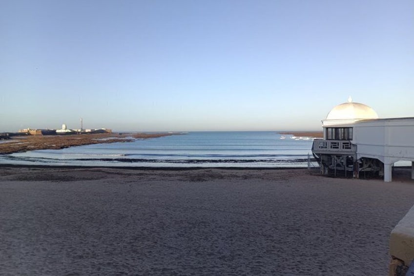 A beach with a white building and a dome structure. 2
