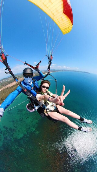 A person paragliding over a body of water with a clear sky. 2