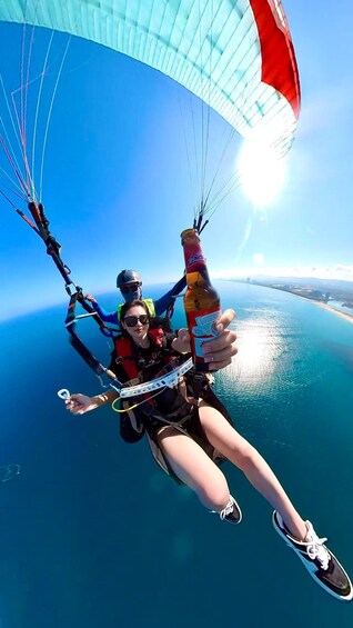 A person paragliding over a body of water with a clear sky. 5