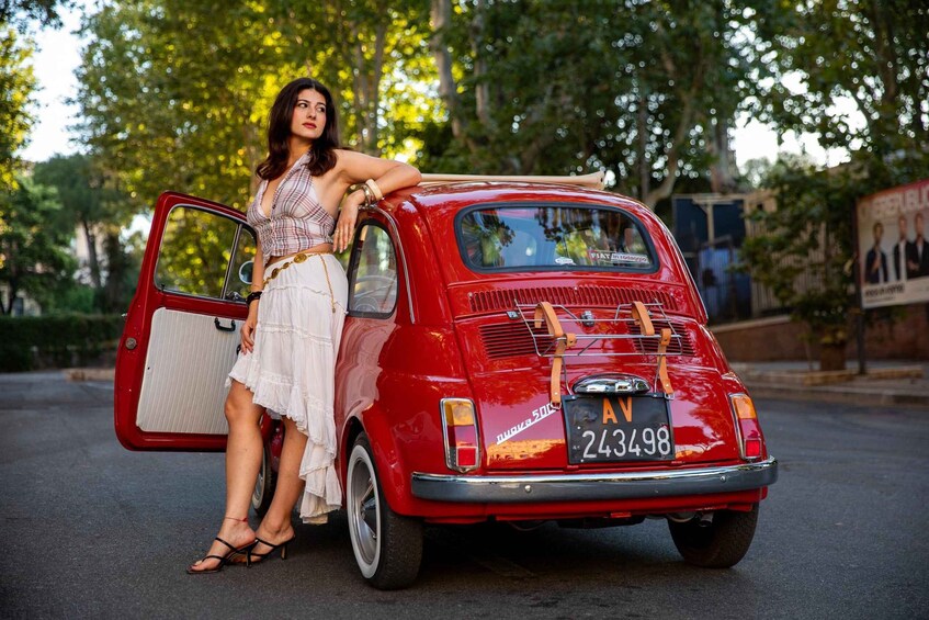 A vintage red car with a license plate 'AV 243498' parked on a street. 2