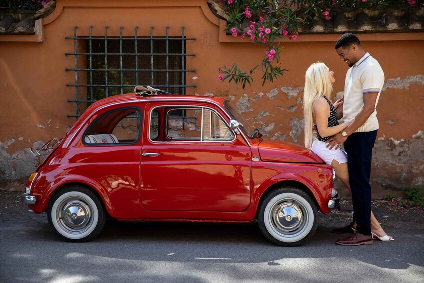 A red vintage car parked in front of a building with a window and a flower box. 5