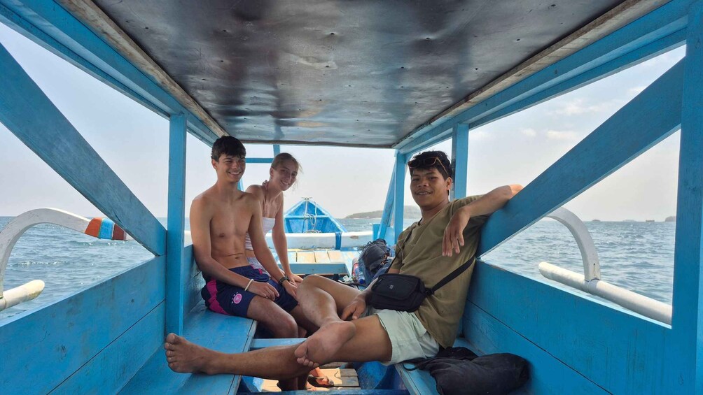 A boat with blue railings and a person sitting on the deck. 4