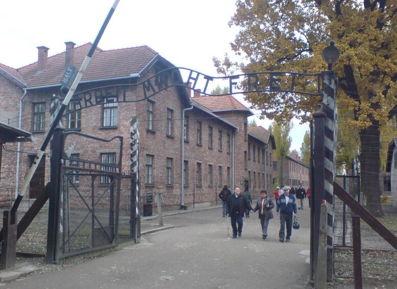 A historical building with a sign reading 'HALT' and people walking in front. 2