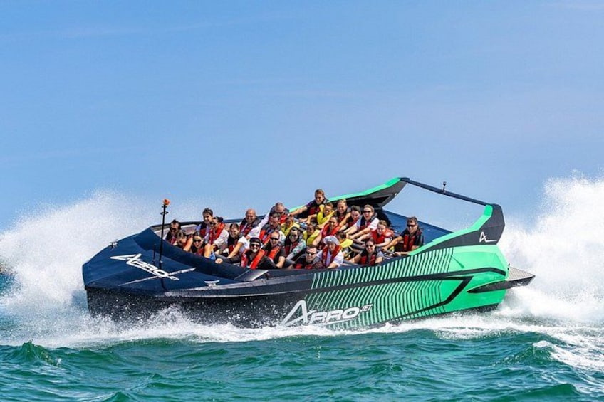 A speedboat with multiple passengers, moving through water. 3