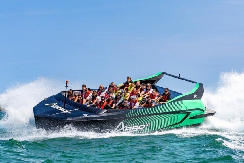 A speedboat with passengers, moving through water. 5