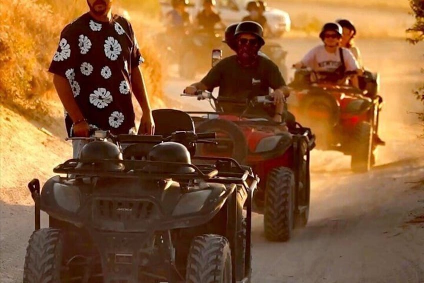 A group of people on ATVs on a dirt road. 2