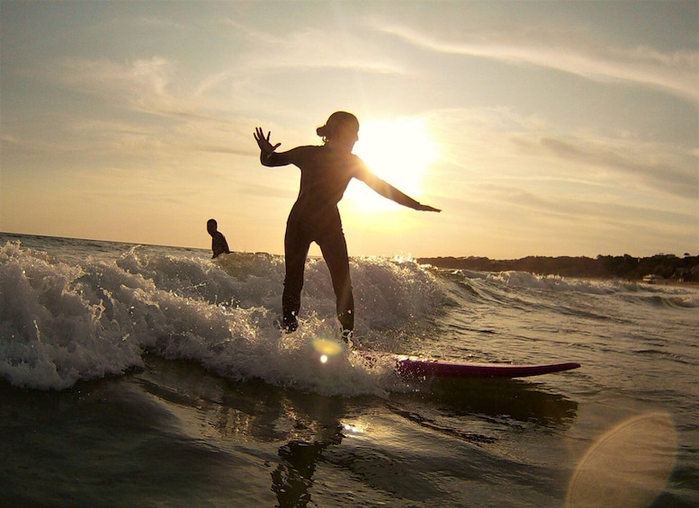 A surfer riding a wave at sunset. 5