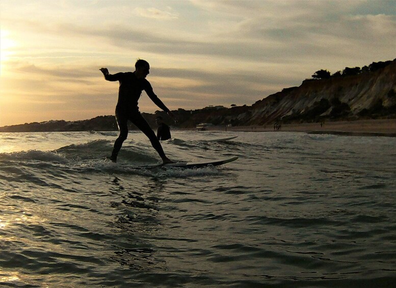 A person surfing on a wave at sunset. 3