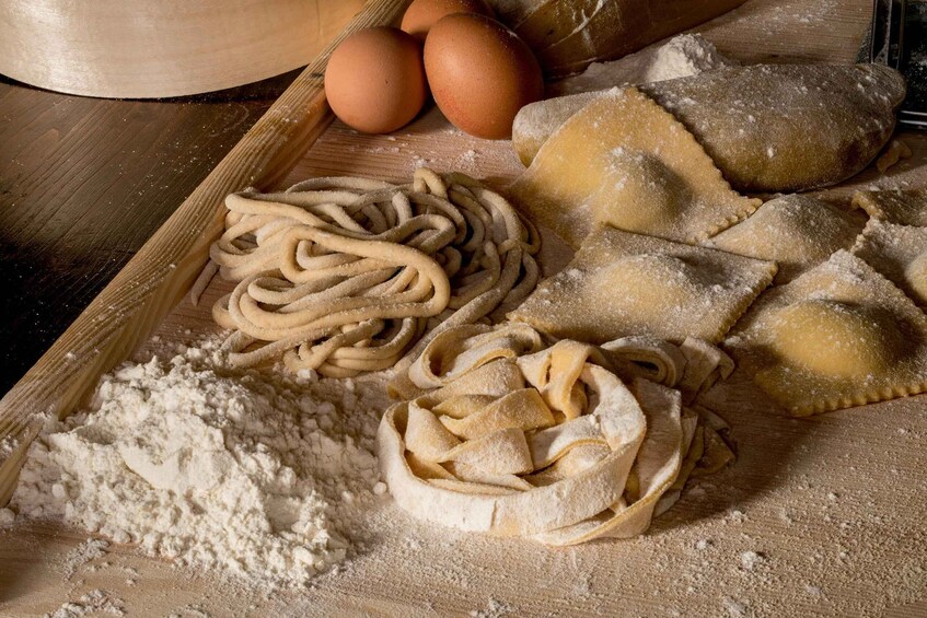 Pasta, eggs, and flour on a wooden surface. 5