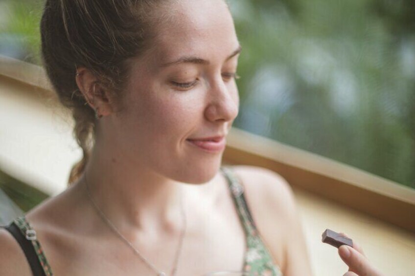 A person holding a small object near a window. 3