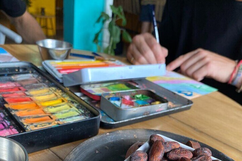 A table with art supplies, including colored pencils, paint, and a palette. 5