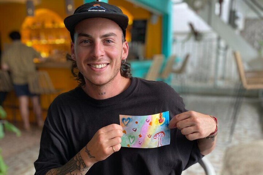 A person holding a colorful card with a heart and smiley face. 2