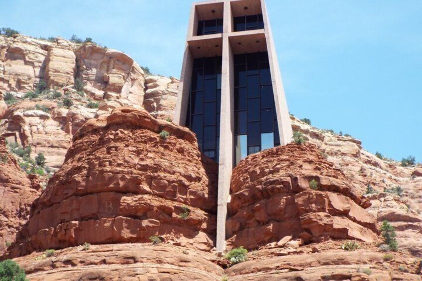 A building with a unique design, situated between two large rock formations. 3