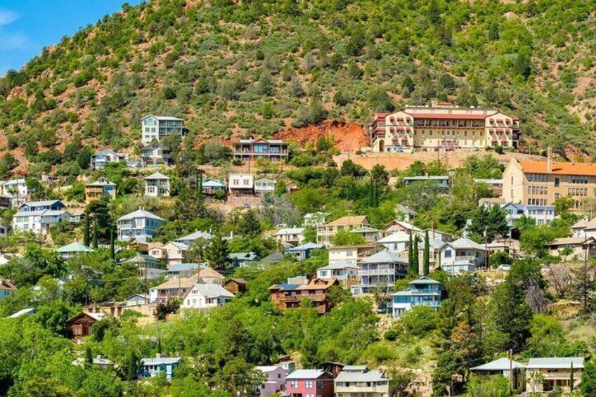 A hillside residential area with houses and a large building on top. 4