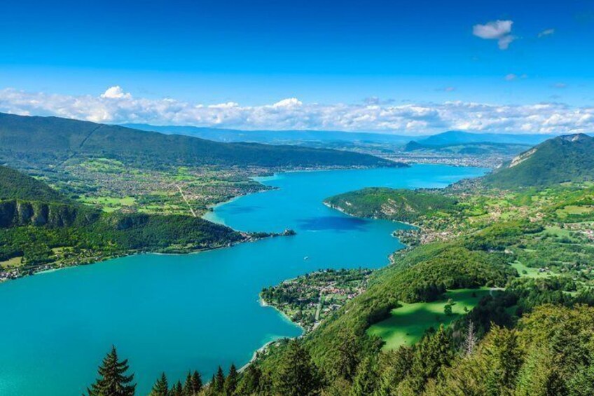 A lake surrounded by mountains and greenery. 1