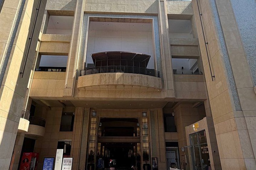 A multi-story building with a central atrium, large windows, and a balcony. 1