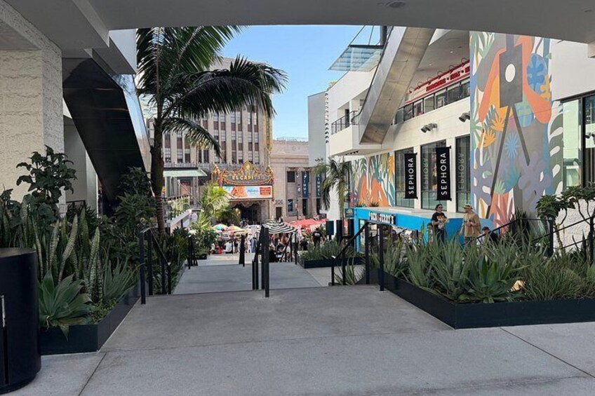 A shopping mall with Sephora stores, palm trees, and outdoor seating areas. 5