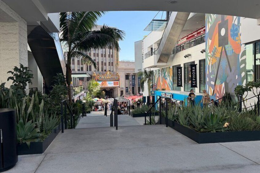 A shopping mall with Sephora stores, palm trees, and outdoor seating areas. 5