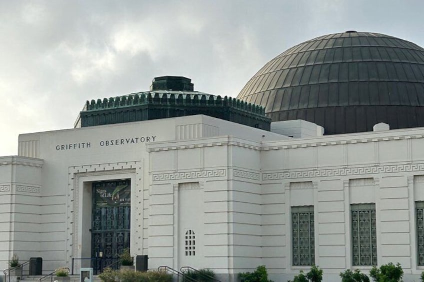 The Griffith Observatory with a large dome and a sign reading 'GRIFFITH OBSERVATORY.' 2