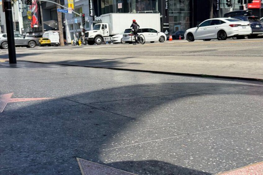 A street with a white car, a cyclist, and a white truck. 4