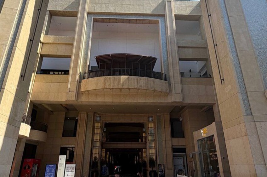 A multi-story building with a central atrium, large windows, and a circular balcony. 3