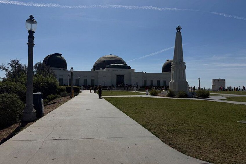 A building with domed roofs, a tall monument, and a clear sky. 4