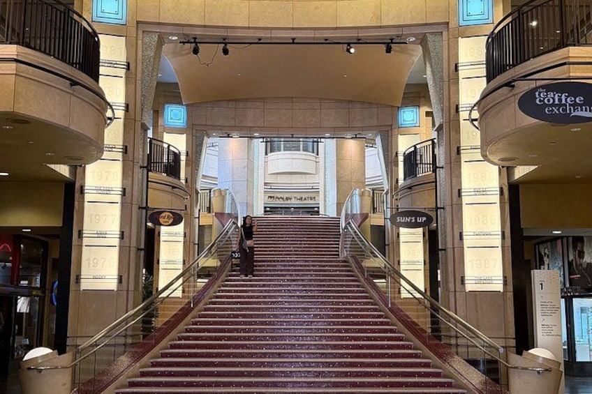 A grand staircase in a shopping mall with shops on either side, including a coffee exchange. 5