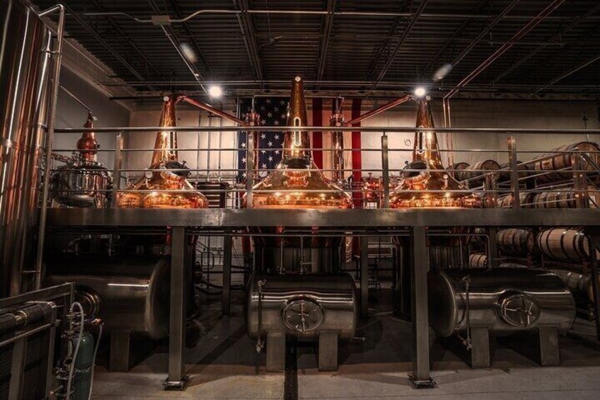 A distillery with copper stills and barrels. 1