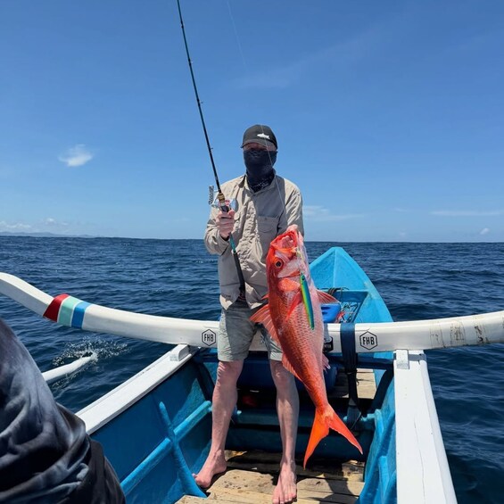A person on a boat holding a large fish. 5