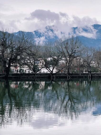 A calm river with reflections of trees and mountains in the background. 3