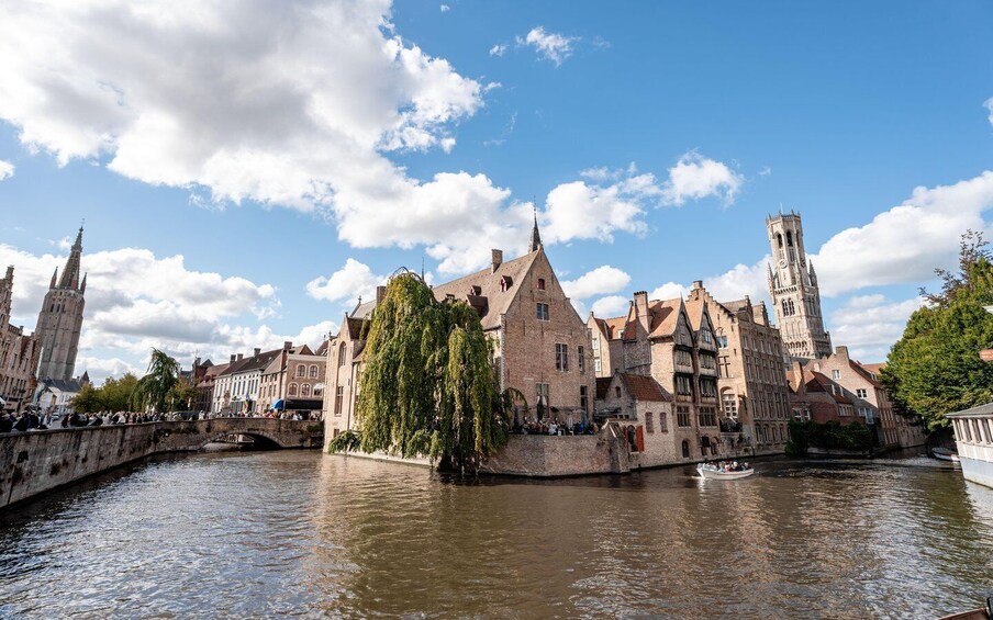 A historic European town with a river, medieval architecture, and a prominent tower. 3