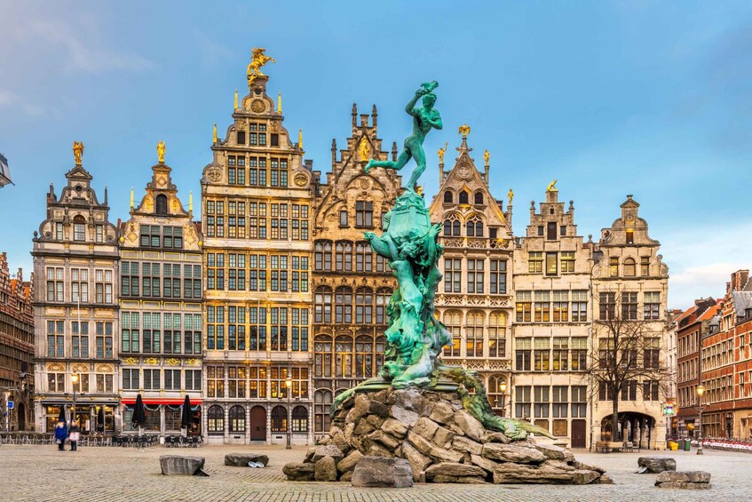 Un edificio storico con architettura elaborata e una statua di una figura su una roccia. 1