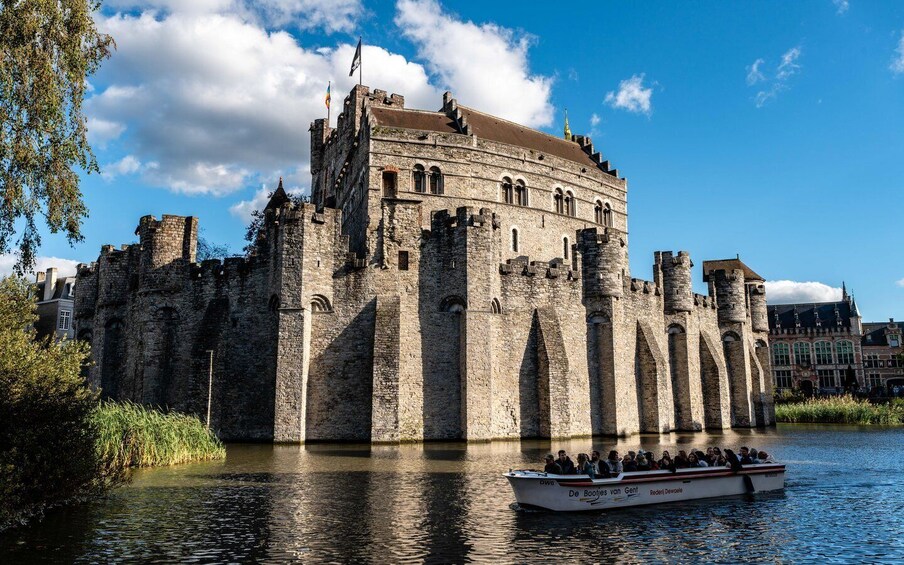 A historic castle by a river with a boat tour. 4