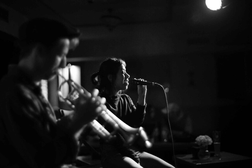 A person playing a guitar in a dimly lit room. 3