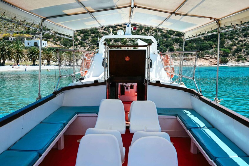 A boat's interior with a view of a beach and clear blue water. 3