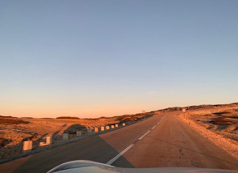 A road curving through a desert landscape with a clear sky. 3