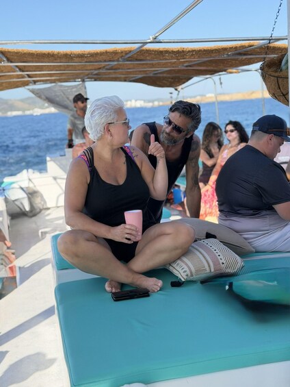 A group of people on a boat with a clear view of the sea and a mountainous landscape in the background. 4