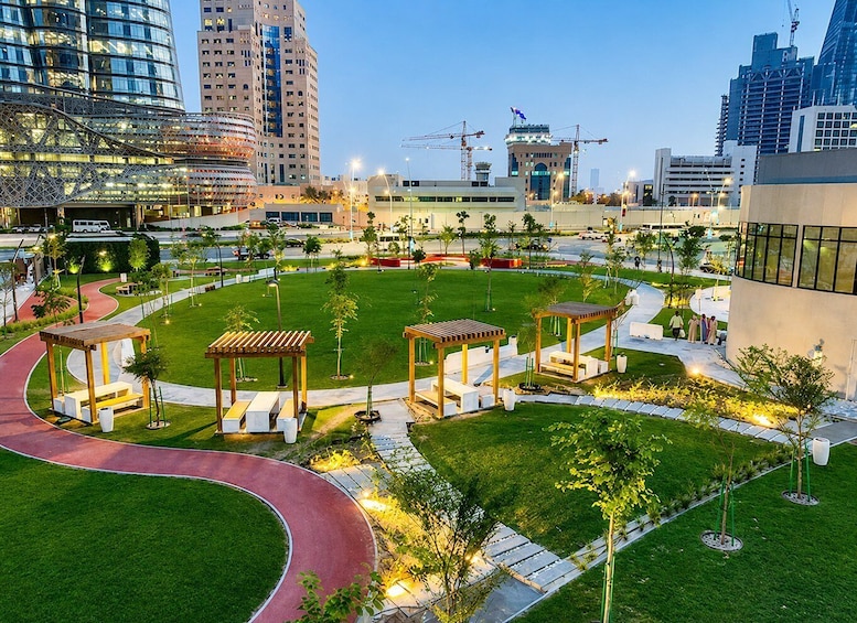 A landscaped urban area with walking paths, green spaces, and modern buildings. 5