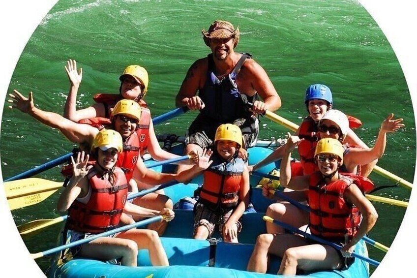A group of people in a raft on a river, wearing life jackets and helmets. 5