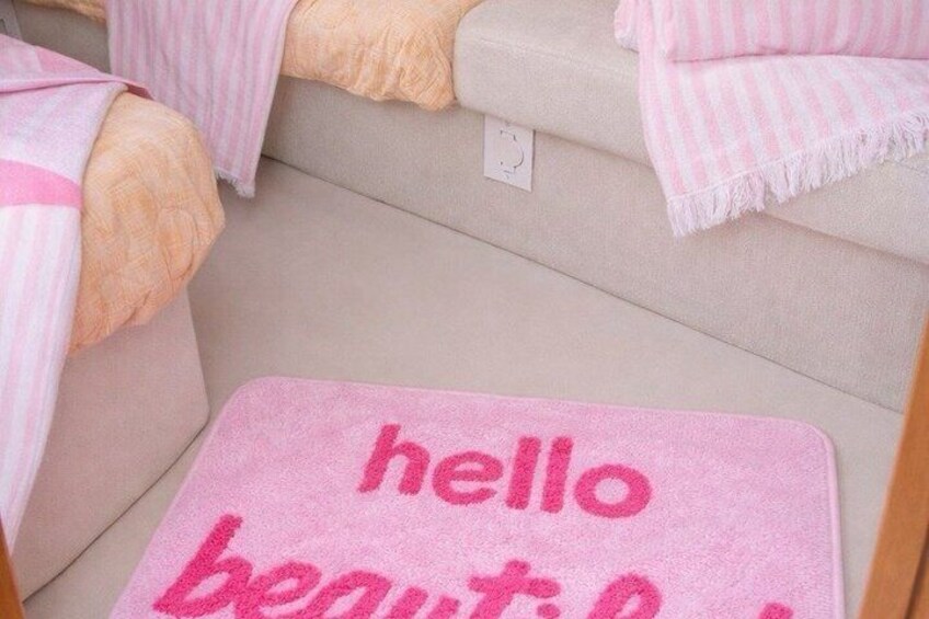 A pink mat with 'hello beautiful' on a beige sofa. 5